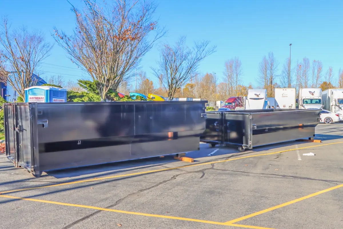 Professional dumpster rental service with roll-off container on residential driveway in Watford City